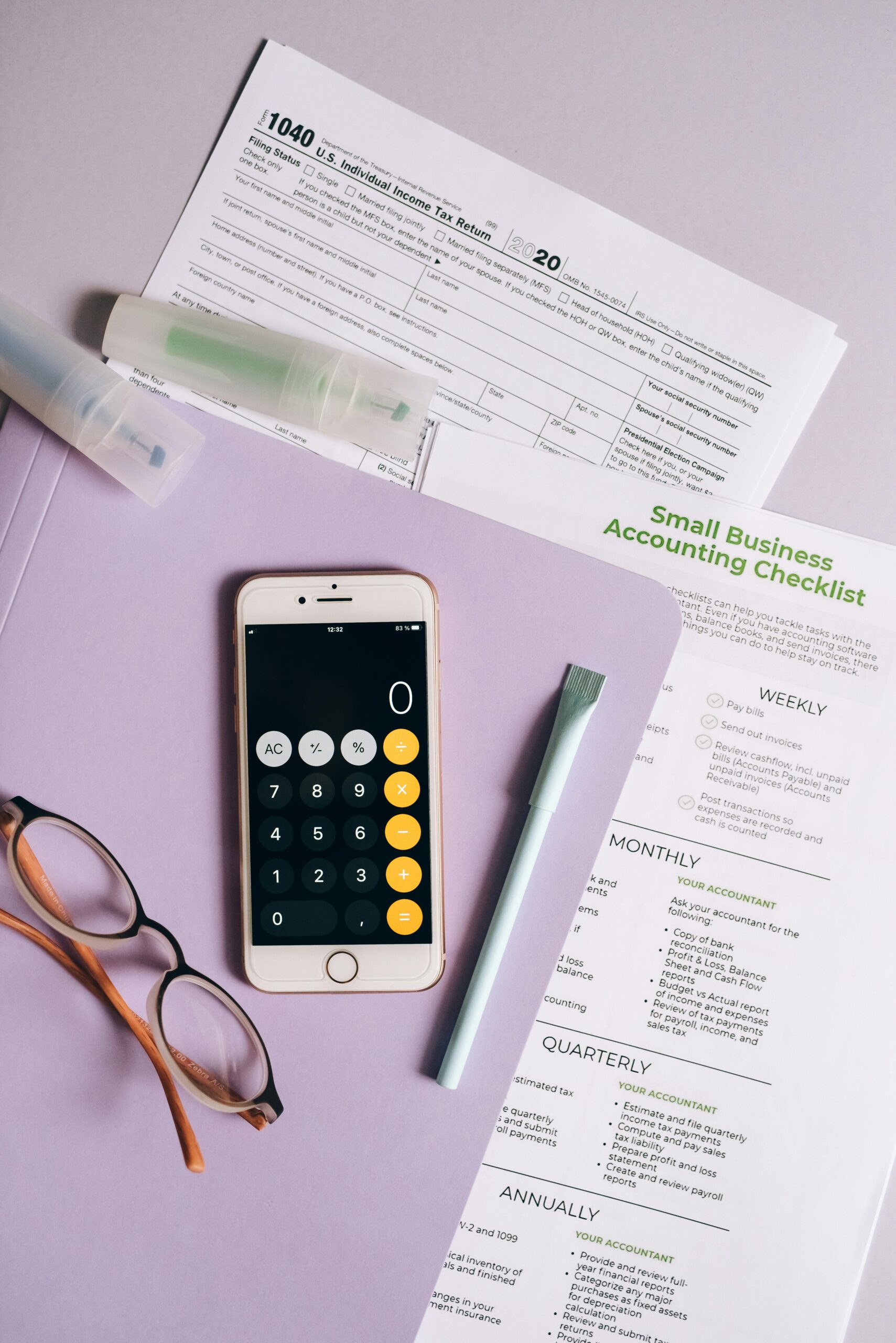Top view of office desk with tax forms, calculator, and accounting tools.